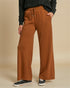 Person wearing brown wide-leg pants on a beige background