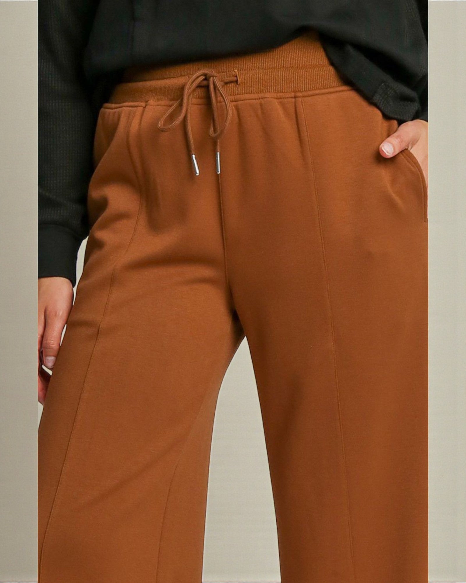 Brown pants with a drawstring waist on a neutral background