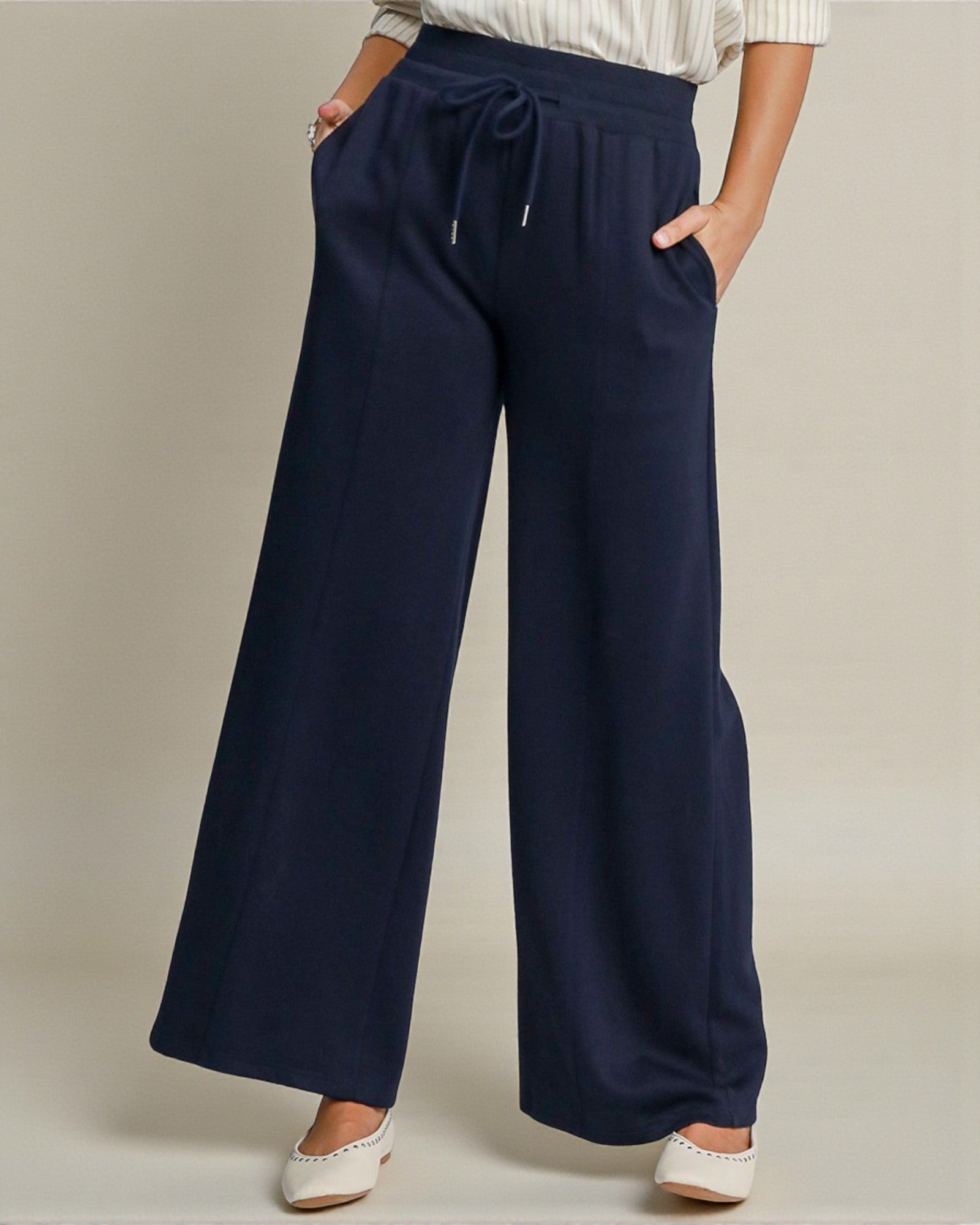 Navy wide-leg pants worn by a person on a neutral background