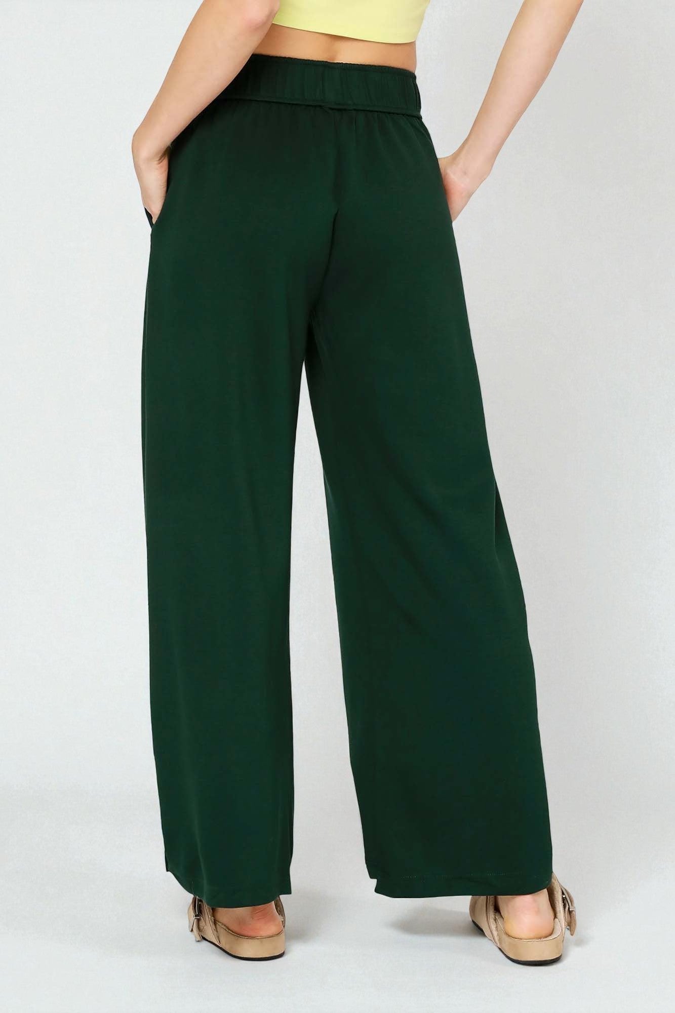 Green wide-leg pants worn by a person on a white background