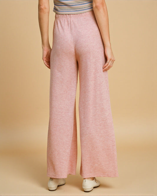 Person wearing pink wide-leg pants on a beige background