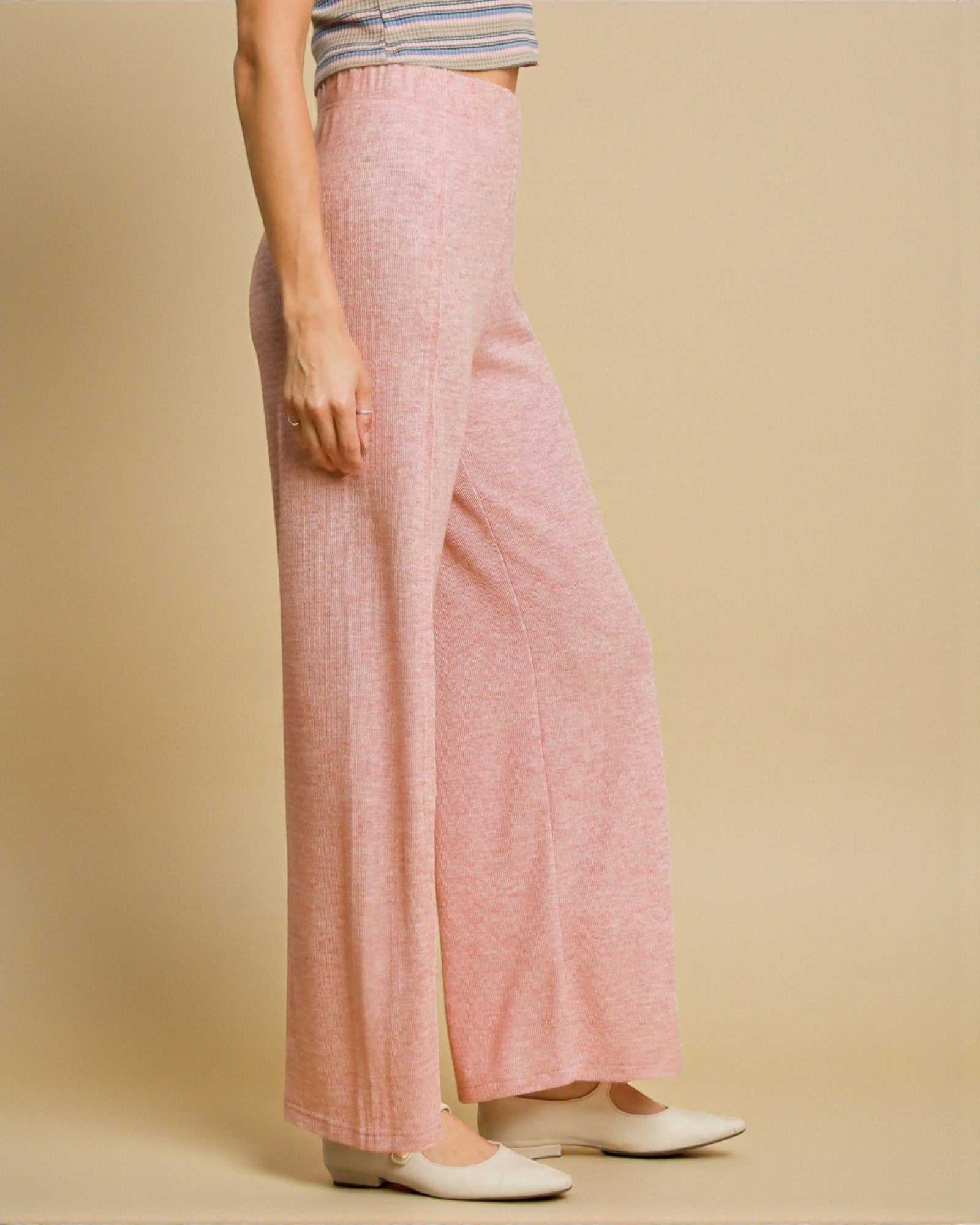 Person wearing pink wide-leg pants on a beige background