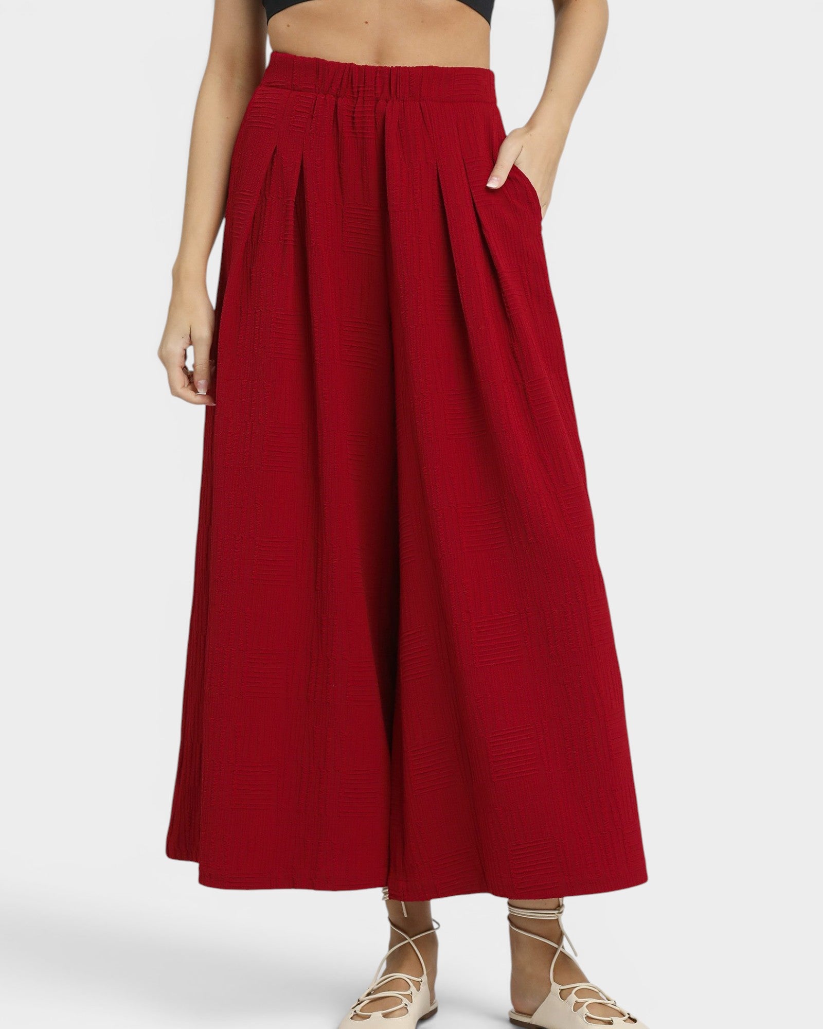 Red wide-leg pants worn by a person on a white background