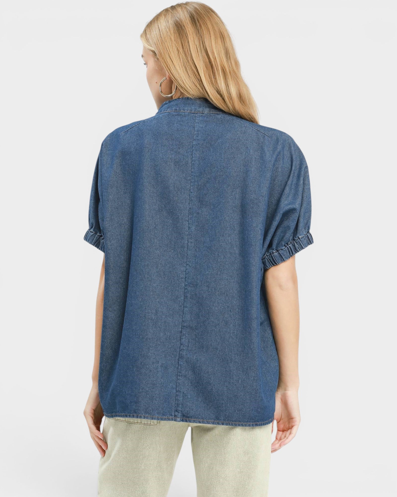Person wearing a blue denim shirt on a white background