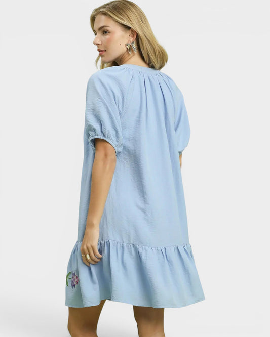 Woman wearing a light blue dress with a white background