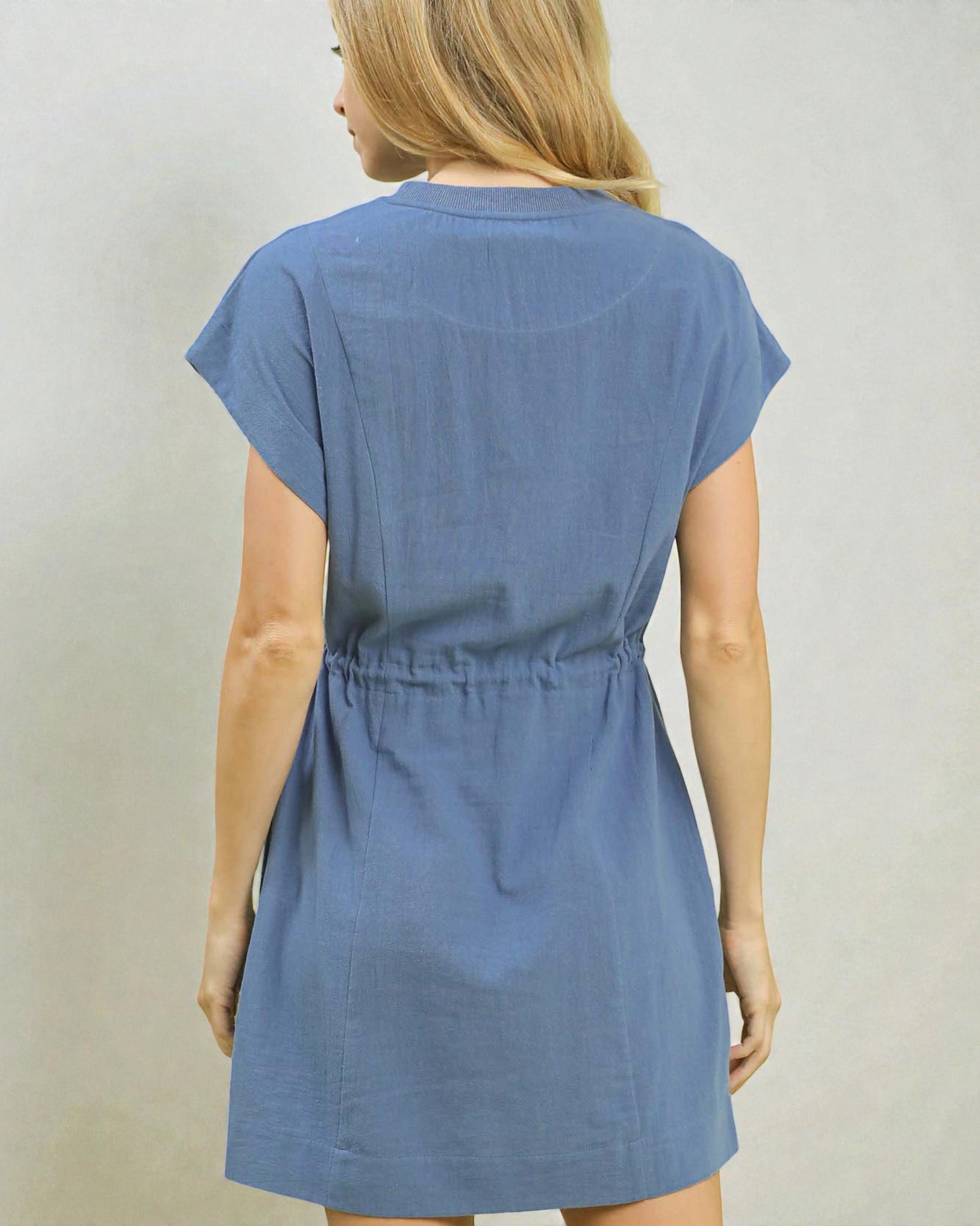 Blue dress worn by a person on a plain background