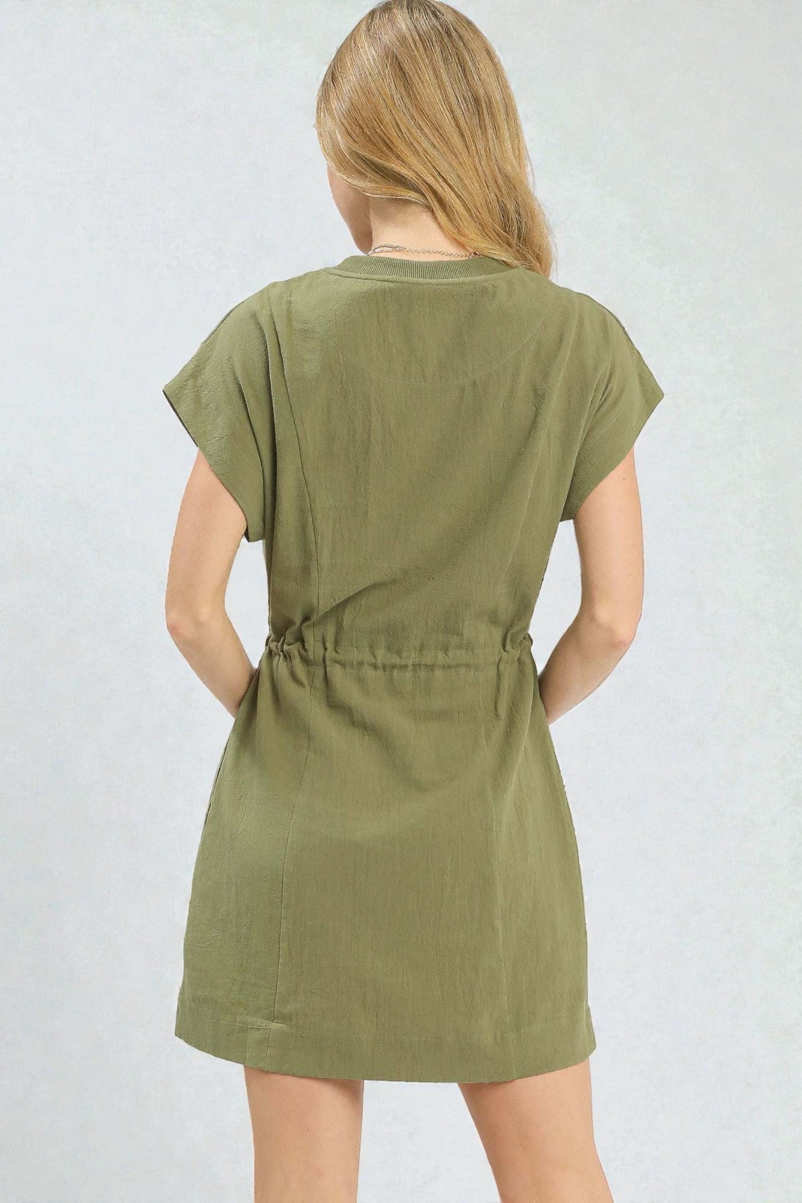 Woman wearing a green dress against a plain background