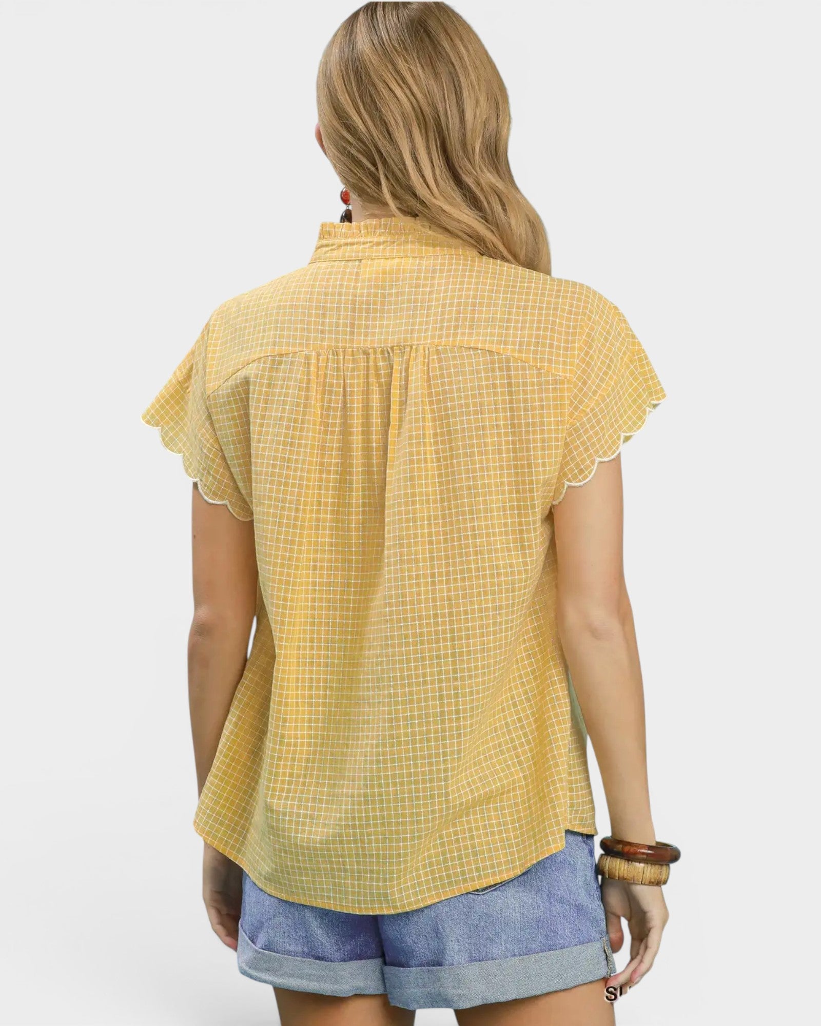 Woman wearing a yellow checkered blouse with short sleeves on a white background