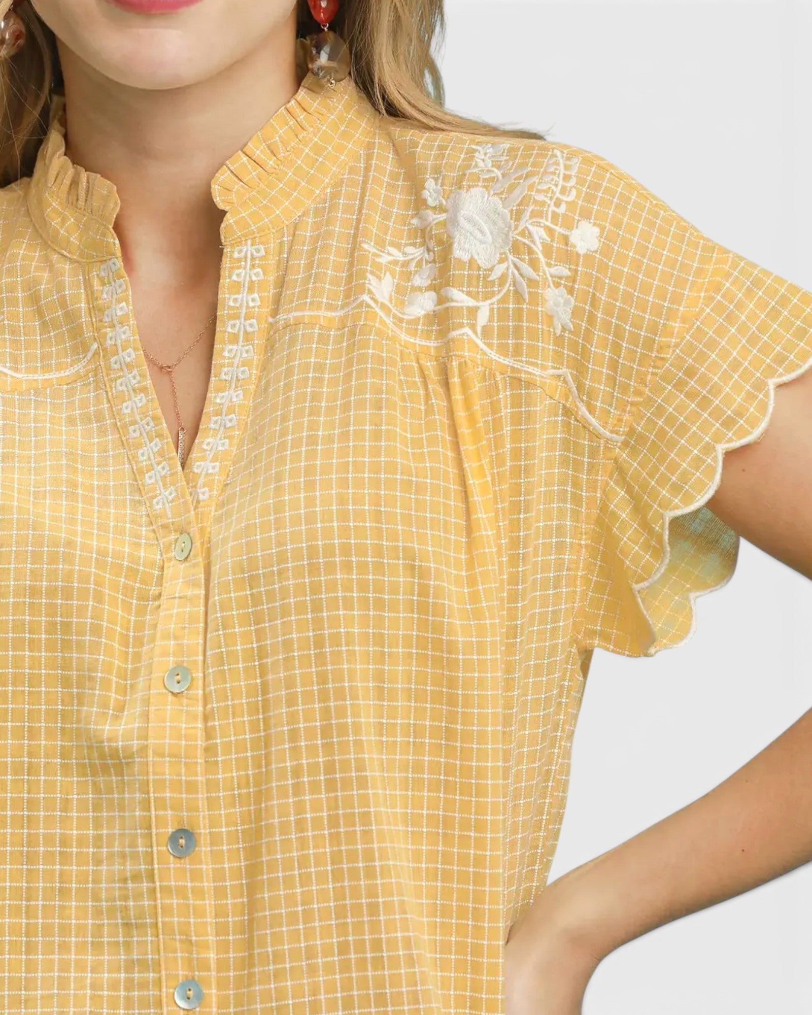 Yellow checkered blouse with floral embroidery on a white background