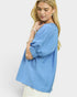 Woman wearing a blue top with a plain background