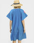 Woman wearing a blue dress with floral sleeves and a straw hat on a light gray background