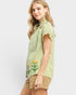 Woman wearing a green and white striped shirt with floral embroidery on a white background