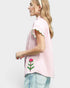 Woman wearing a pink checkered shirt with floral designs on a white background