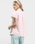 Woman wearing a pink checkered blouse with floral embroidery on a white background
