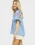 Woman wearing a light blue embroidered blouse on a white background