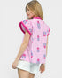 Woman wearing a pink and white striped shirt with floral patterns on a white background