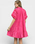 Woman wearing a pink dress with floral patterns on a white background