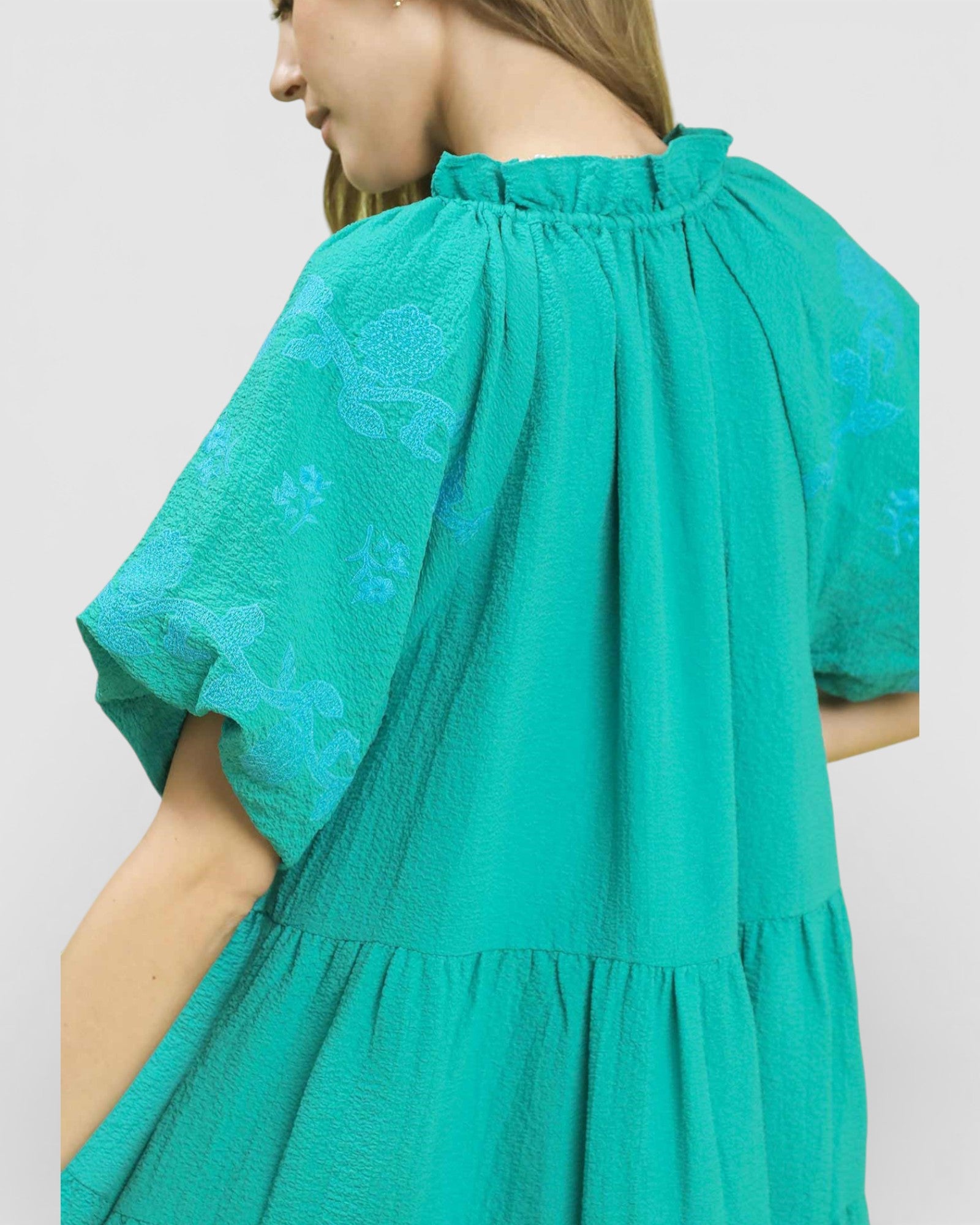 Green dress with floral pattern on a plain background