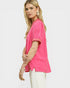 Woman wearing a bright pink blouse with a plain background