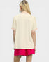 Person wearing a beige top with pink trim and pink shorts on a white background