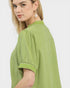 Woman wearing a green blouse with embroidered details on a white background