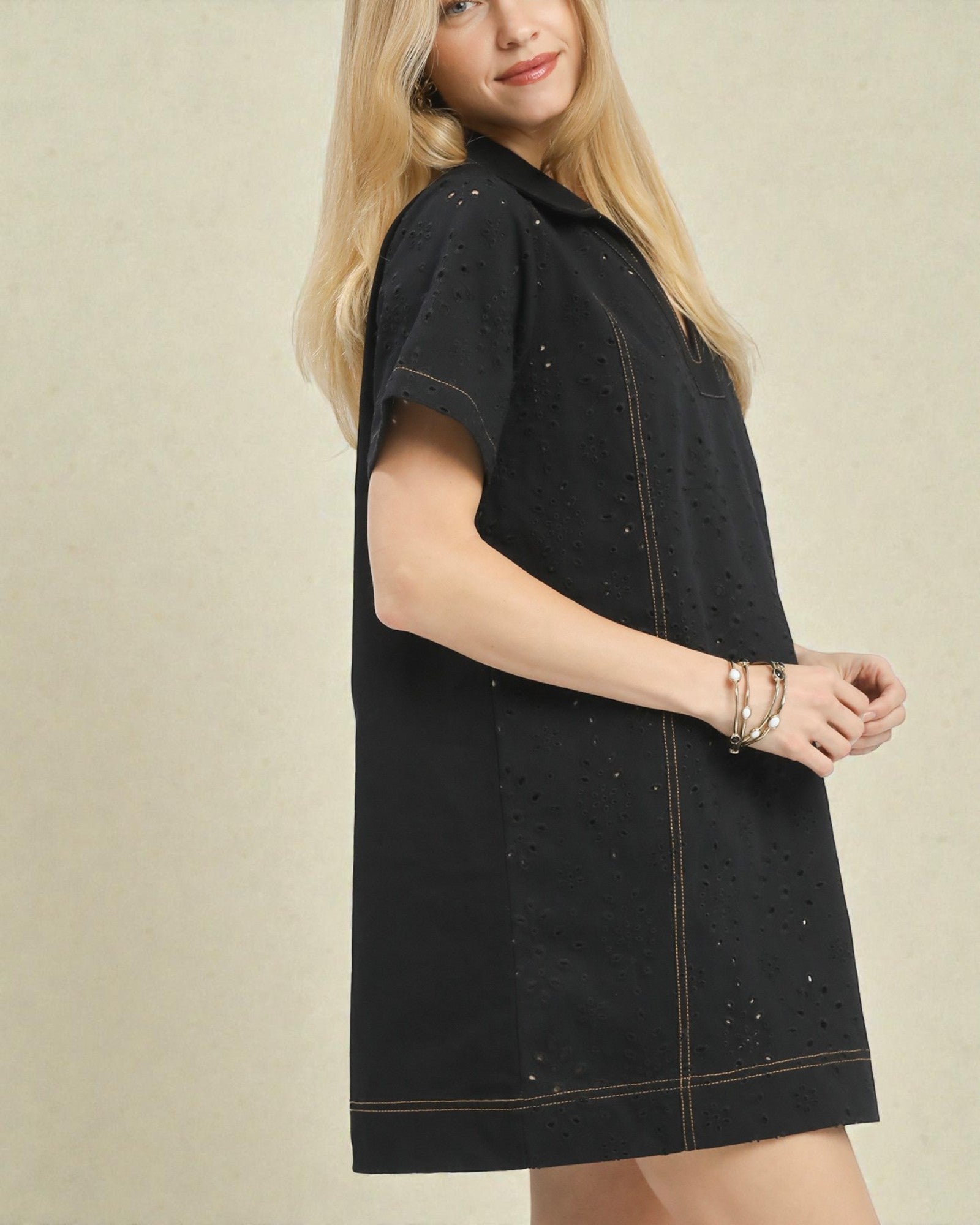 Woman wearing a black dress with a beige background