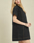 Woman wearing a black dress with a beige background