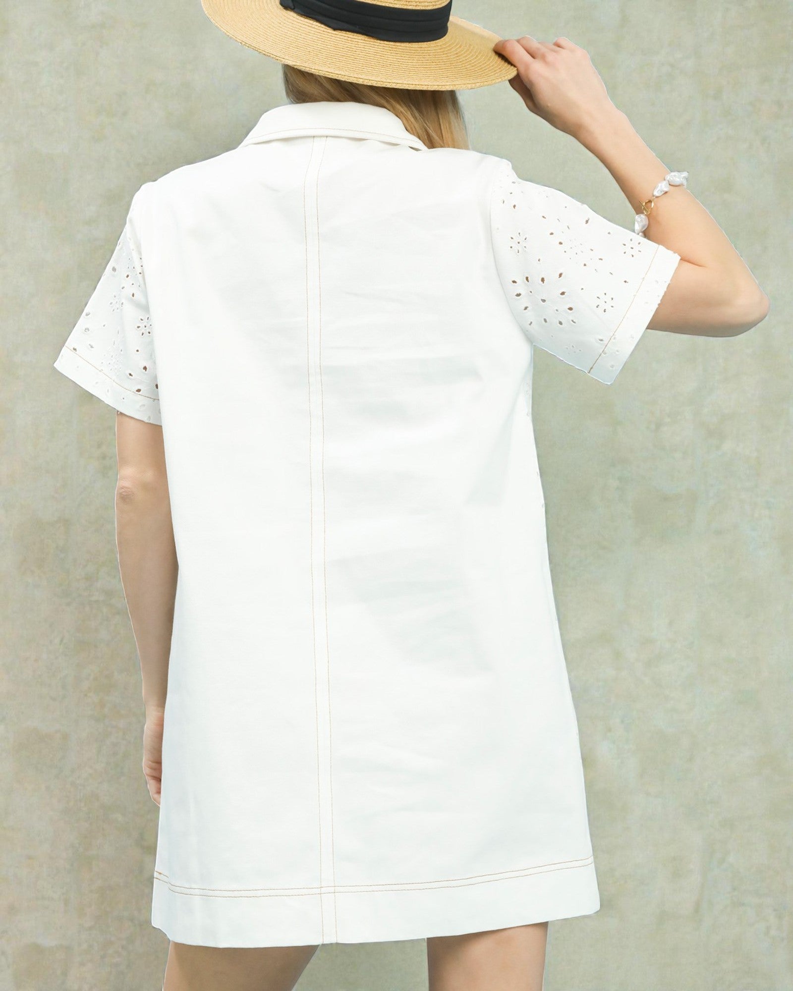 Person wearing a white dress with a textured background