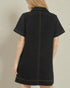 Black dress with white trim on a beige background