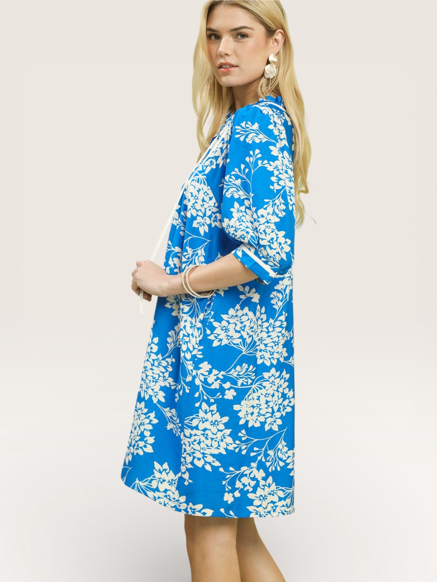 Woman wearing a blue floral dress on a white background