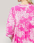 Pink dress with white floral pattern on a plain background