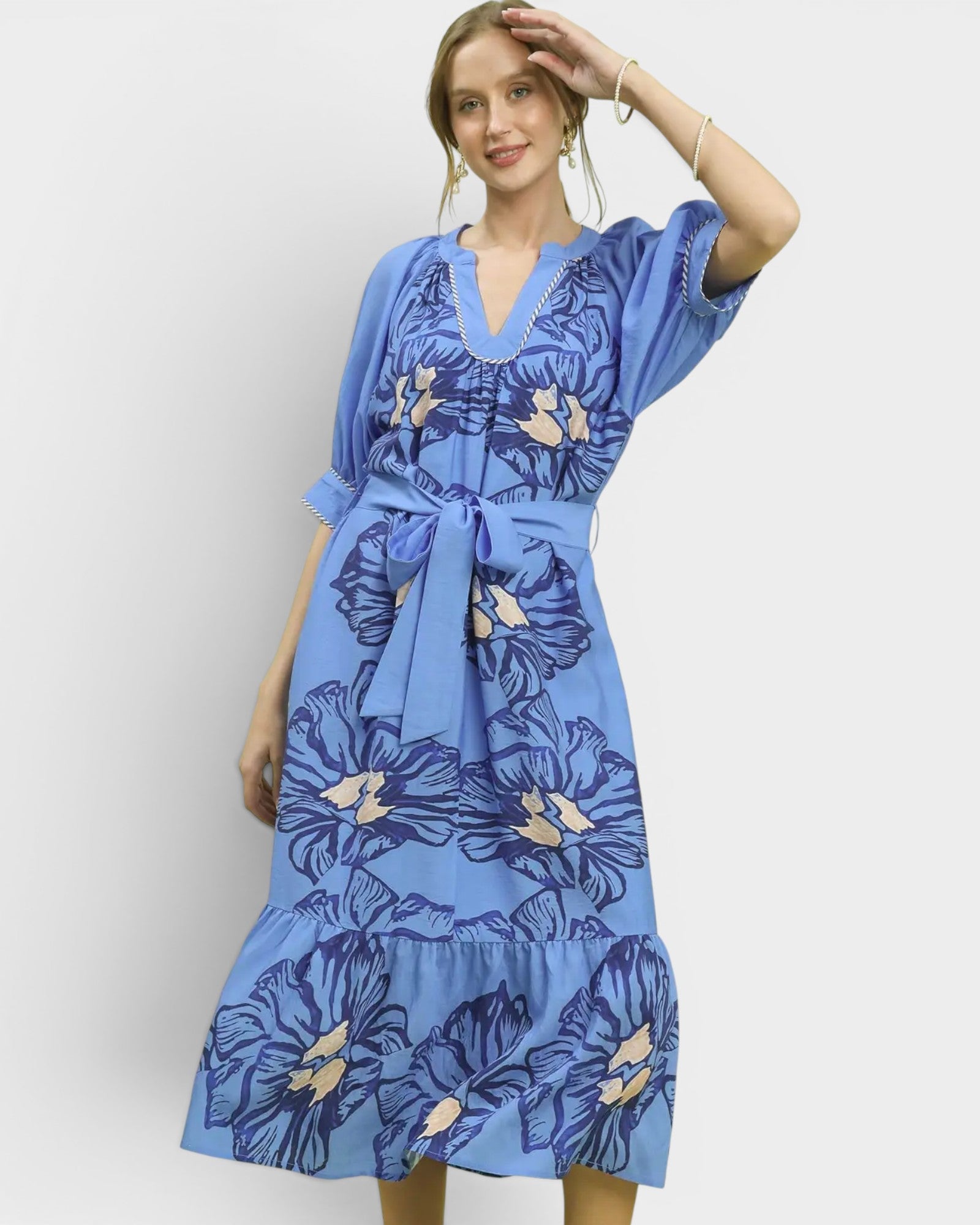 Woman wearing a blue floral dress against a white background