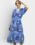 Woman wearing a blue floral dress against a white background