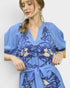Woman wearing a blue dress with a floral pattern on a white background