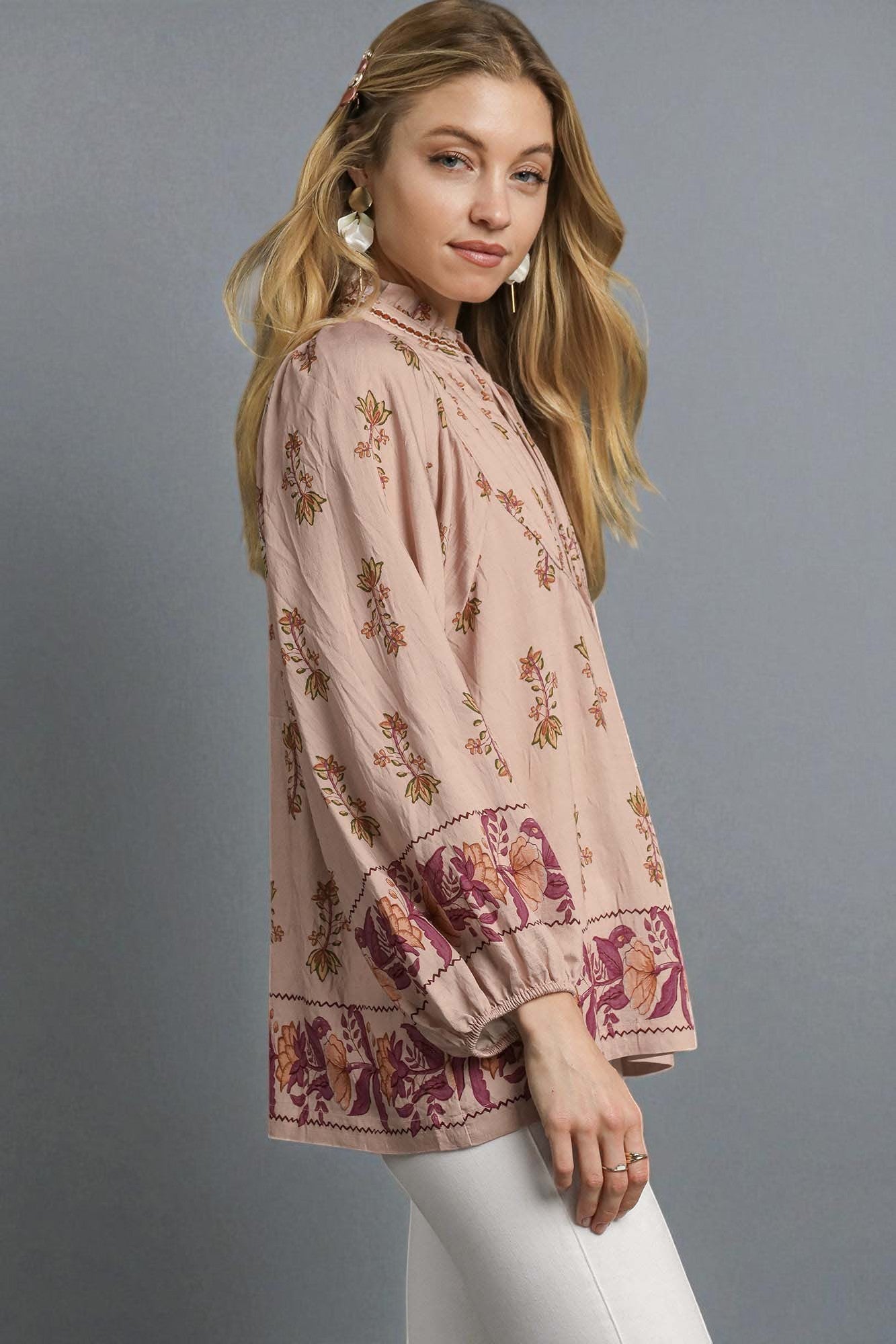 Woman wearing a floral blouse against a gray background