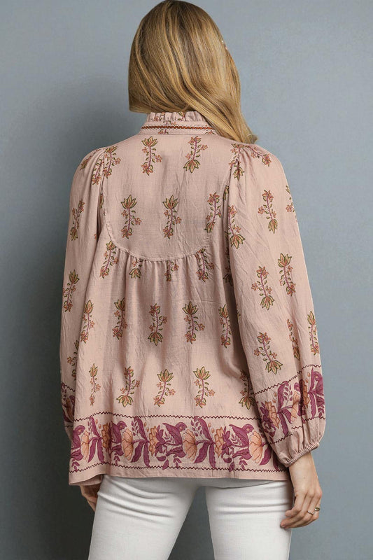 Woman wearing a pink floral blouse against a gray background