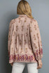 Woman wearing a pink floral blouse against a gray background