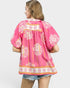 Woman wearing a pink floral patterned top on a white background