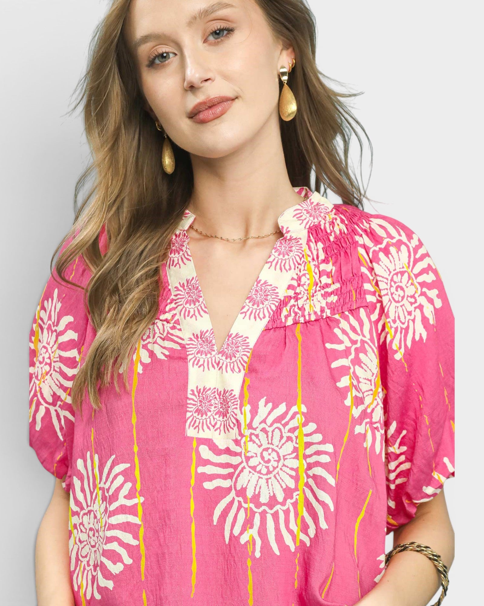 Woman wearing a pink floral blouse with a plain background