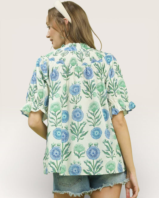 Woman wearing a floral patterned shirt with a plain background