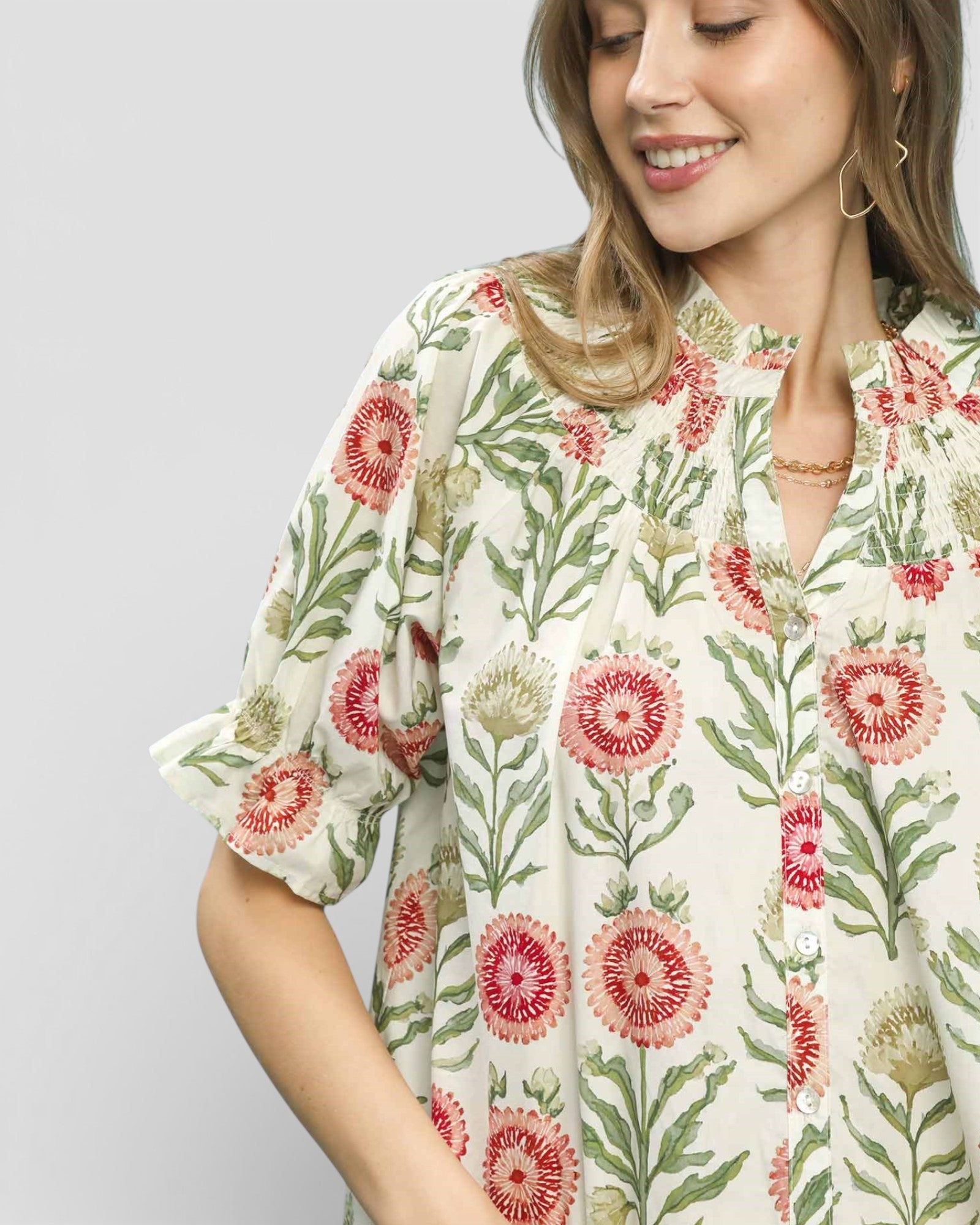 Woman wearing a floral patterned dress against a plain background