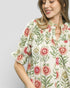 Woman wearing a floral patterned dress against a plain background