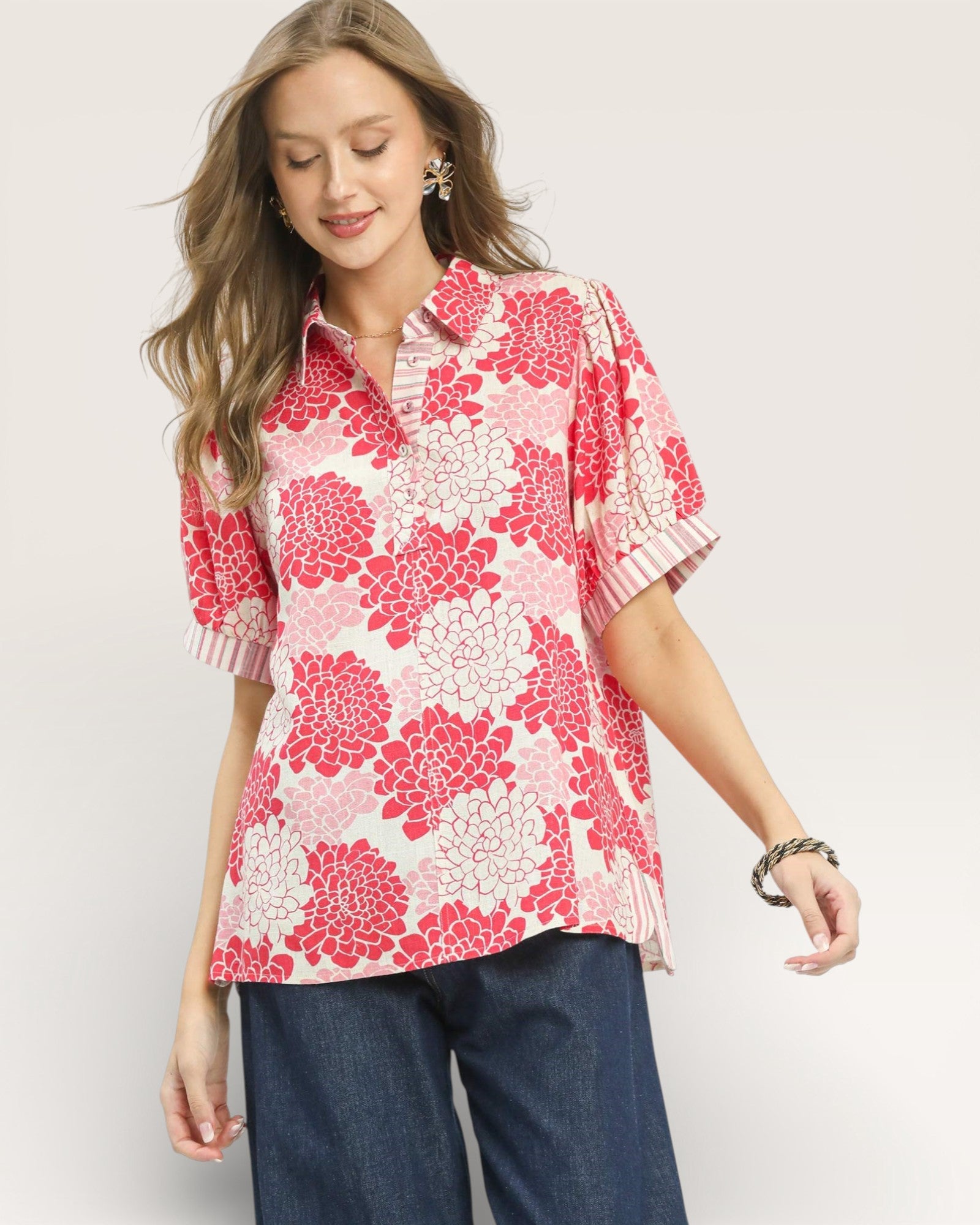 Woman wearing a pink floral blouse with a plain background