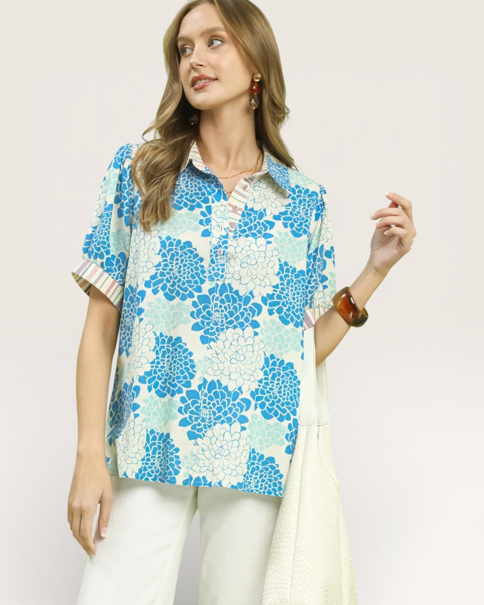 Woman wearing a blue floral blouse with a plain white background