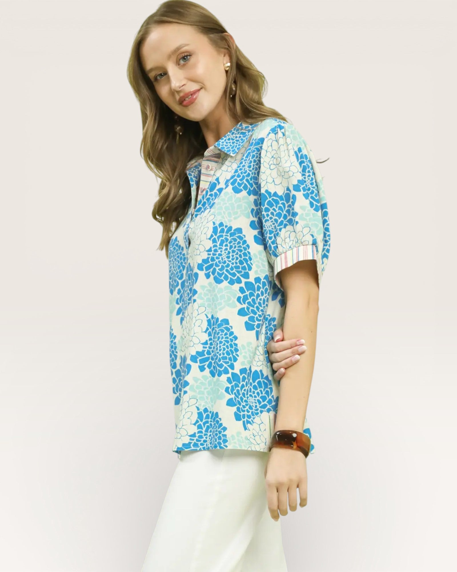 Woman wearing a floral patterned shirt on a plain background