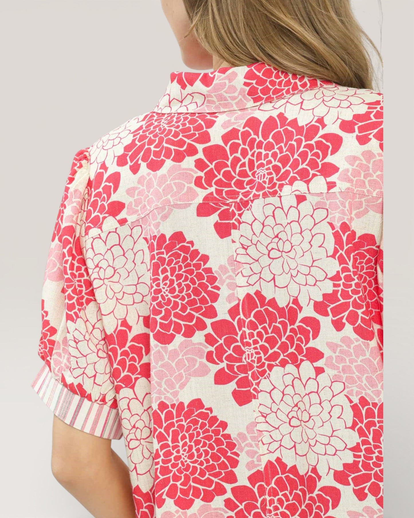 Floral patterned garment with pink and white flowers on a plain background