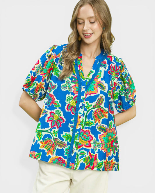 Woman wearing a colorful floral blouse on a white background