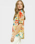Woman wearing a colorful floral blouse on a white background