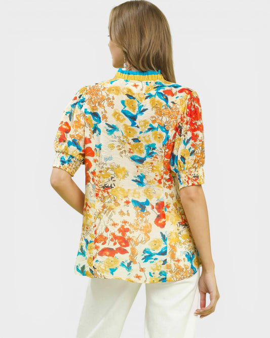 Woman wearing a colorful floral blouse on a white background