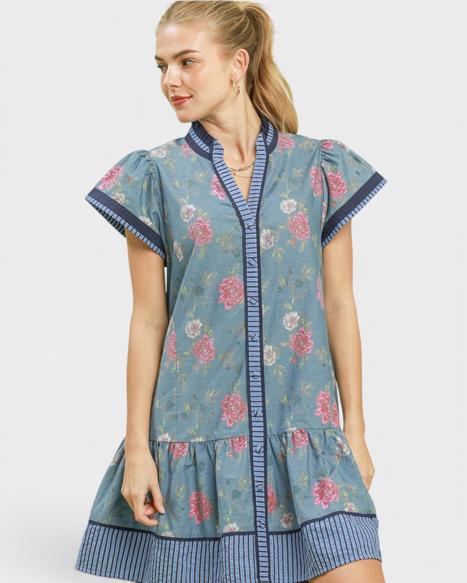 Woman wearing a floral dress with a blue border on a white background